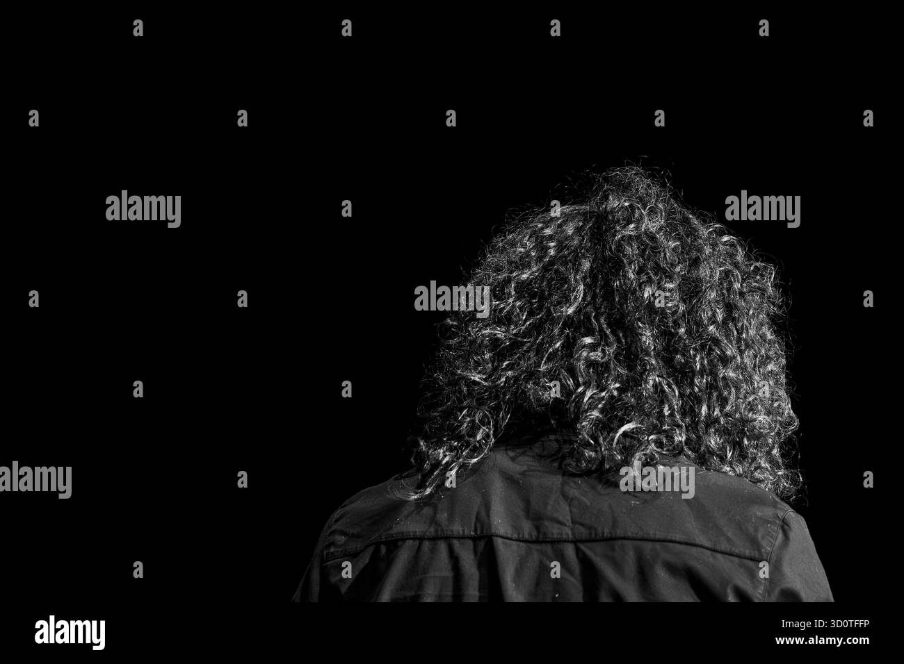 Versteckte Locken. Schwarzer Raum, Hintergrund. Einfarbige Farbtöne. Stockfoto