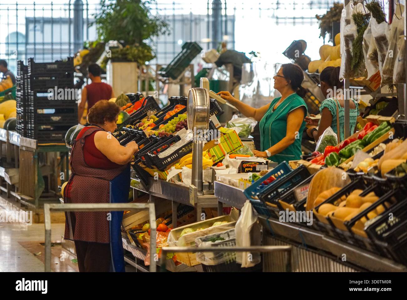 Verkäufer und Käufer an belebten Gemüseständen im Time Out Market in Lissabon Portugal Stockfoto