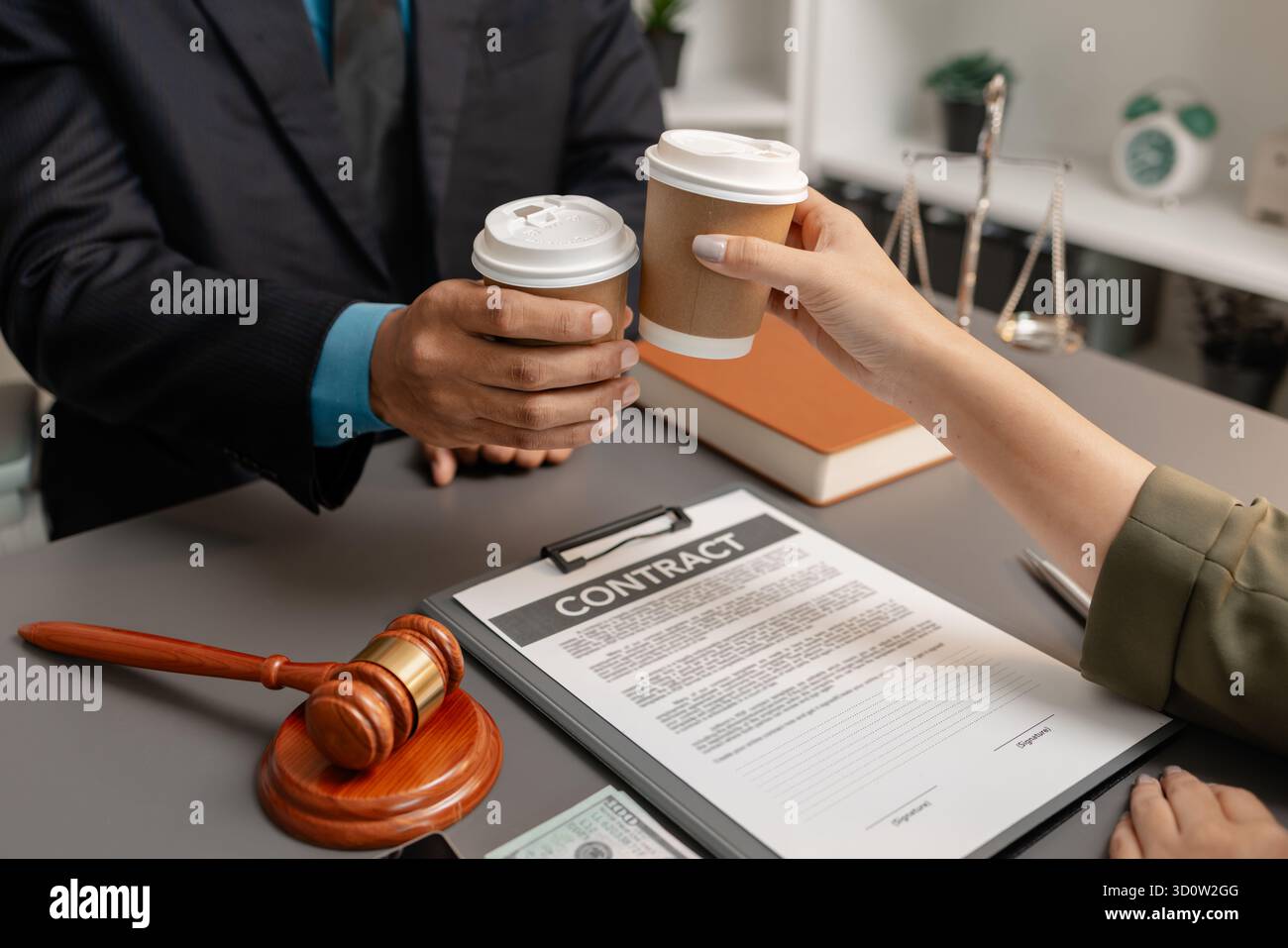 Ein Anwalt und ein Kunde feiern den erfolgreichen Abschluss einer Rechtsvereinbarung mit einem Kaffeetoast im Büro, der Vertrauen, Partnerschaft und symbolisiert Stockfoto