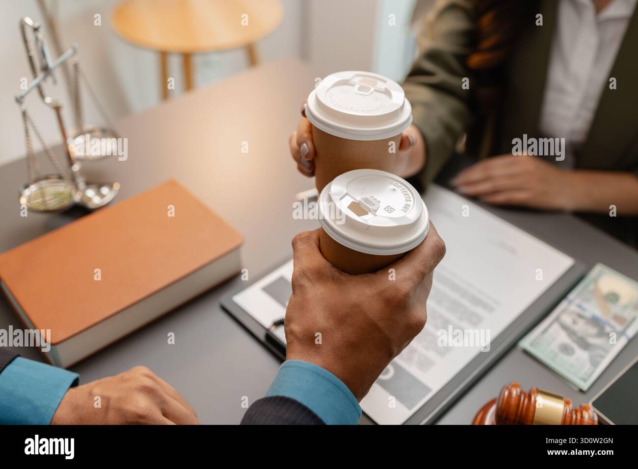 Ein Anwalt und ein Kunde feiern den erfolgreichen Abschluss einer Rechtsvereinbarung mit einem Kaffeetoast im Büro, der Vertrauen, Partnerschaft und symbolisiert Stockfoto