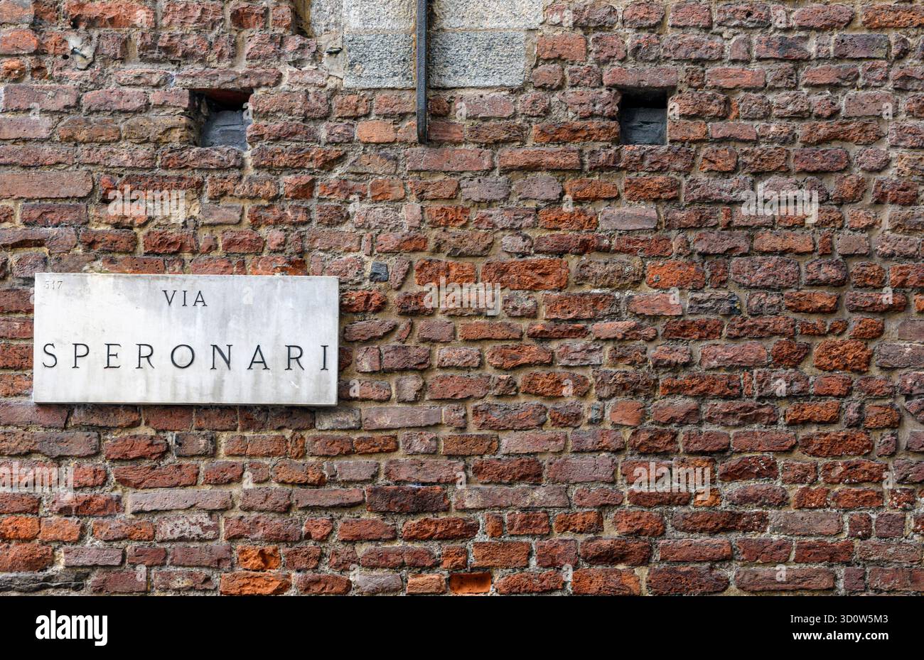 Straßenschild an einer roten Backsteinmauer entlang der Via Speronari, Mailand, Italien Stockfoto