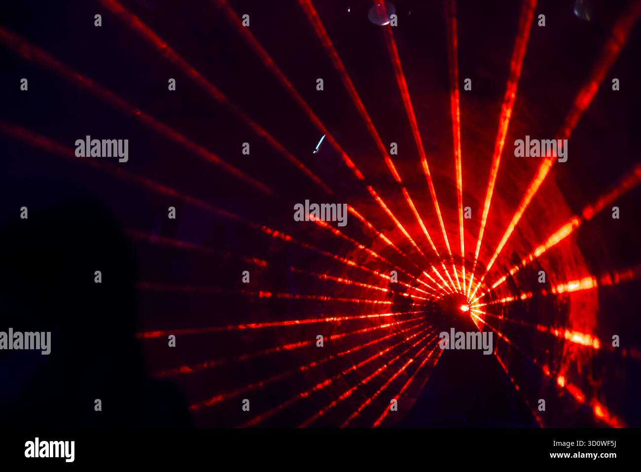 Roter Laser Light Tunnel mit leuchtenden Strahlen in dramatischer Umgebung Stockfoto