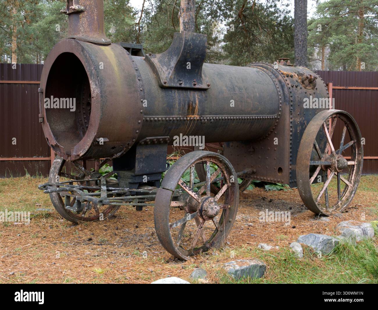 Eine Vintage-Dampfmaschine mit großen Metallrädern und zylindrischem Gehäuse. Hergestellt aus vernietetem Metall. Stockfoto