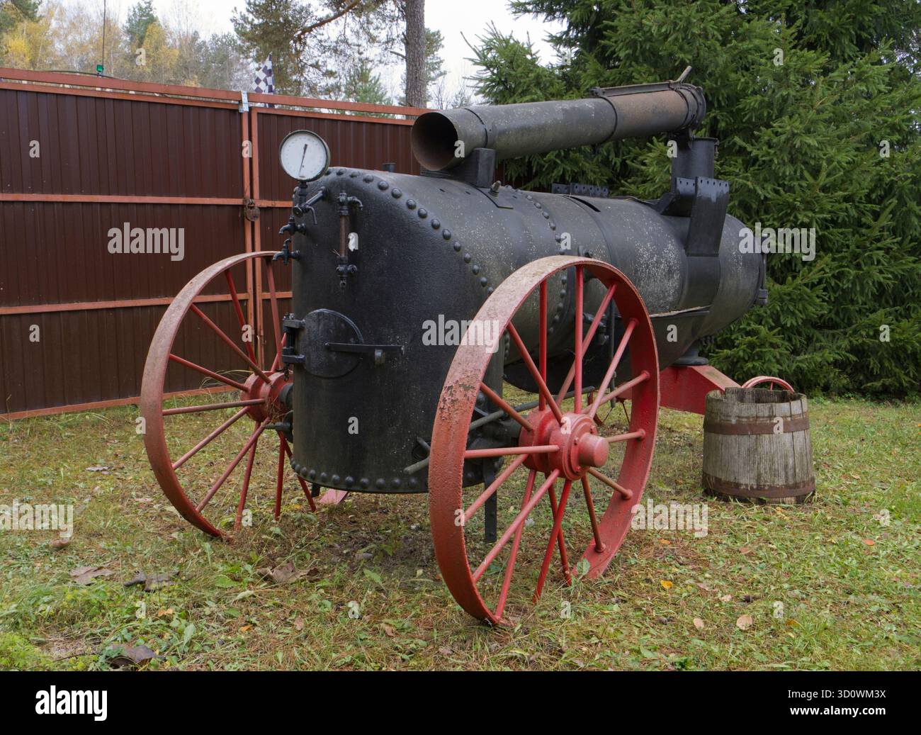 Eine Vintage-Dampfmaschine mit großen Metallrädern und zylindrischem Gehäuse. Hergestellt aus vernietetem Metall. Stockfoto