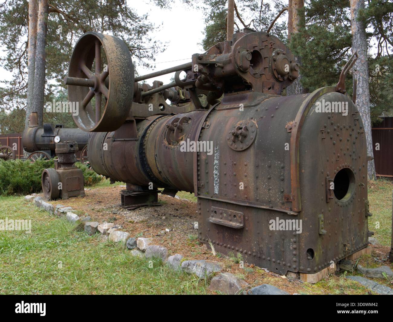 Eine Vintage-Dampfmaschine mit großen Metallrädern und zylindrischem Gehäuse. Hergestellt aus vernietetem Metall. Stockfoto