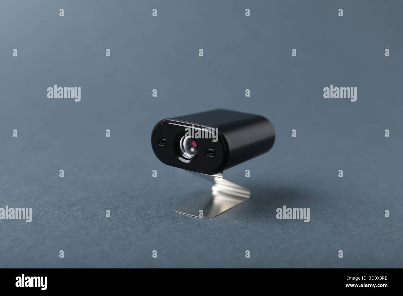 Versteckte Spionagekamera auf grauem Hintergrund, Nahaufnahme Stockfoto