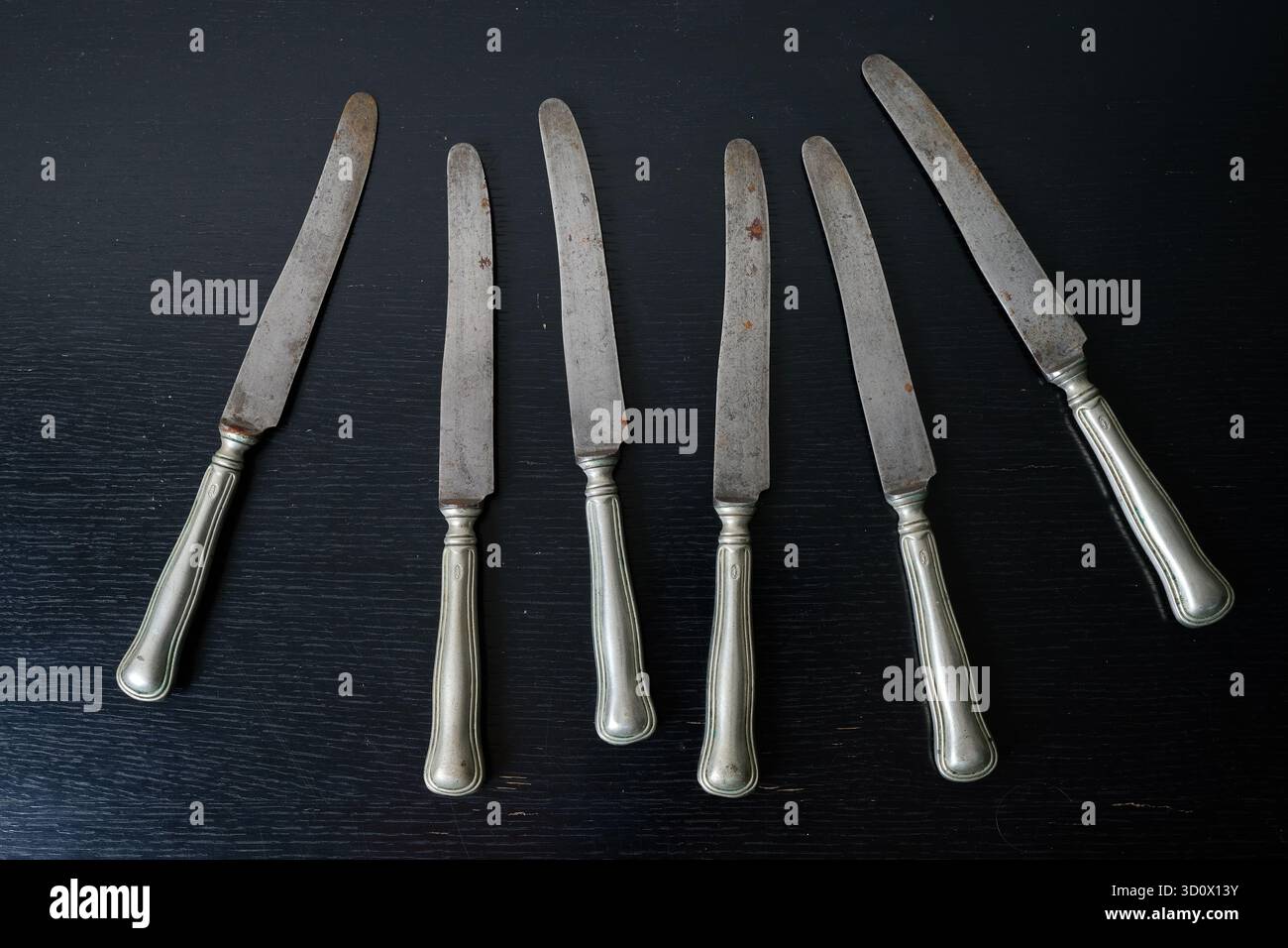 Rostiges Silbergeschirr Messer und Gabel auf schwarzen Möbeln Stockfoto