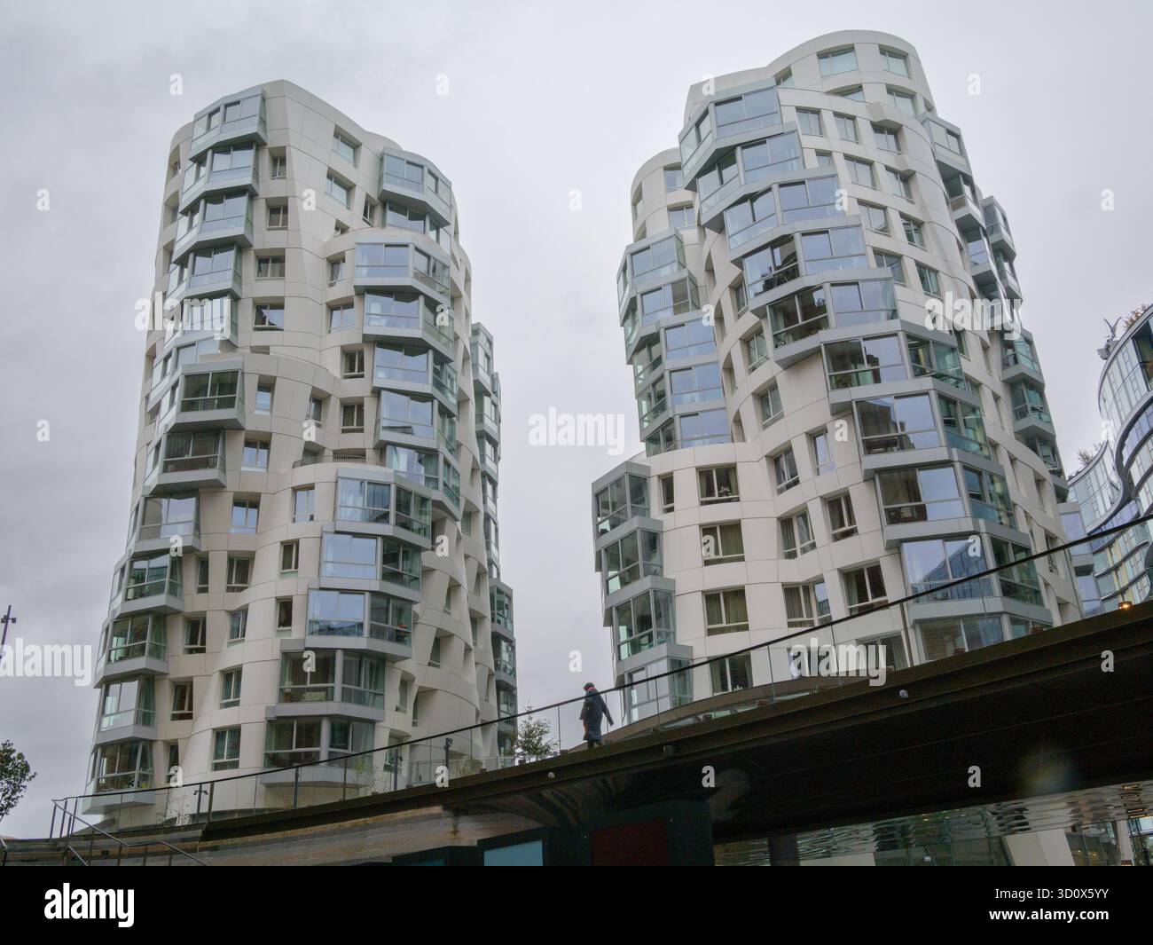 Fußgängerweg vor den von Gehry entworfenen Hochhauswohnungen im Prospect Place Battersea London UK Stockfoto