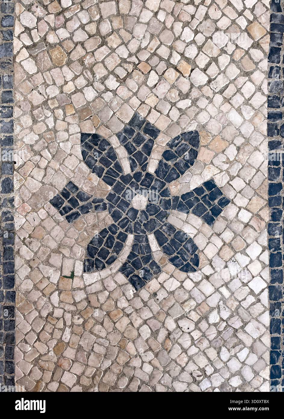 Lissabon, Portugal – Pflaster calcada portuguesa mit Blumenrosette aus Basalt und Kalksteinen. Stockfoto
