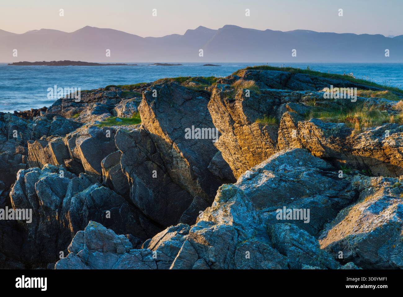 Felsige Küste im Frühsommermorgen Sonnenlicht auf der nordöstlichen Seite der Insel Runde, Herøy kommune, Møre og Romsdal, Norwegen. Stockfoto