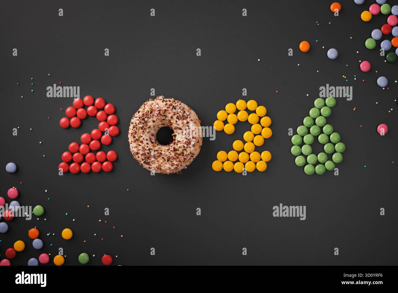 2026 Ziffern mit bunten Dragee Bonbons und einem Donut auf dunklem Hintergrund. Neujahrsidee. Stockfoto