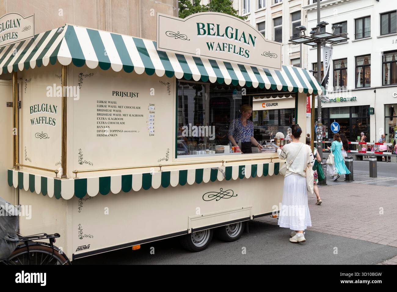 Frau bestellt köstliche Waffeln an einem Waffelstand im Zentrum von Antwerpen in Belgien. Stockfoto