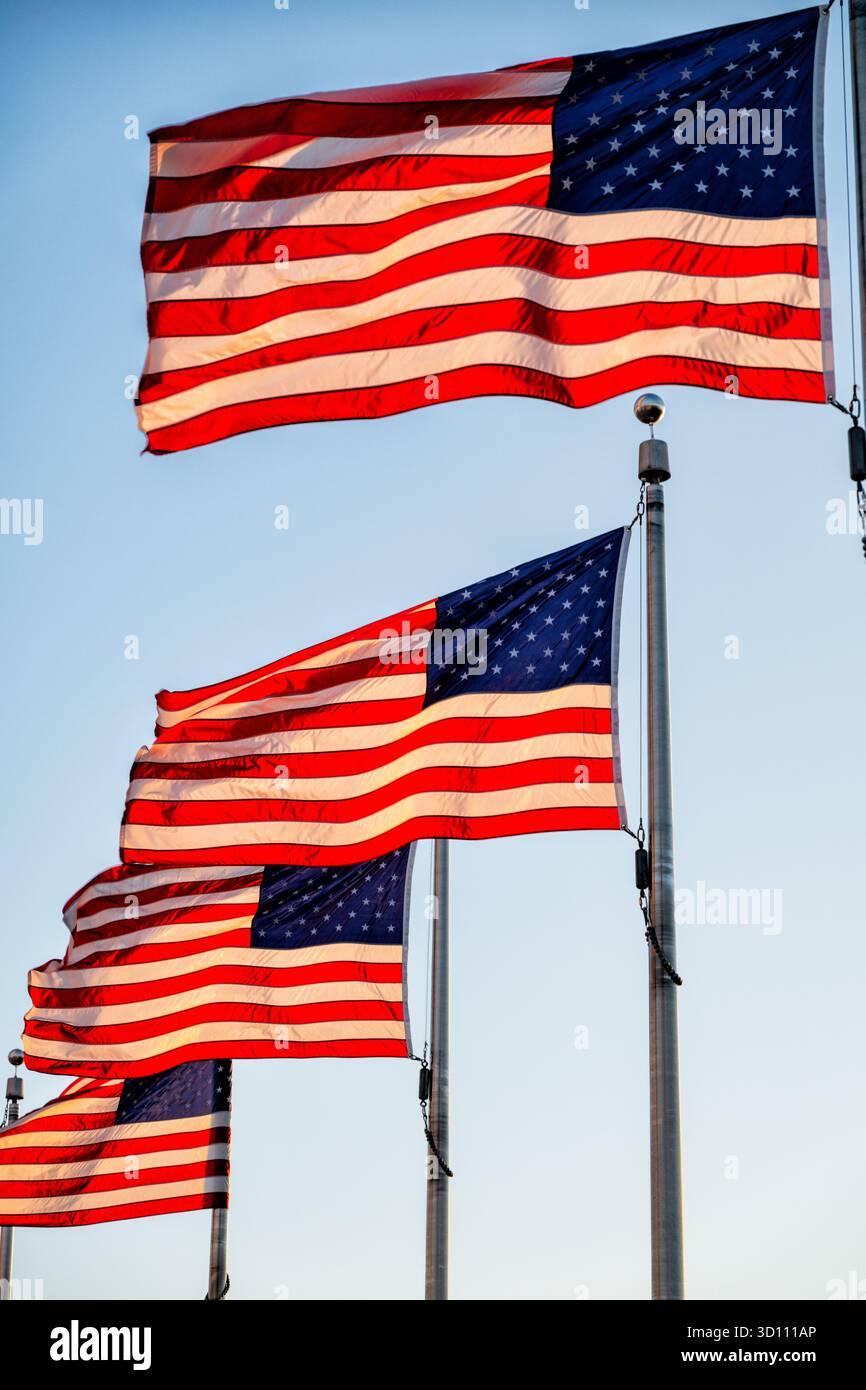 Amerikanische Flaggen im Golden Hour Light Washington DC // WASHINGTON DC – amerikanische Flaggen werden auf dem Gelände des Washington Monuments ausgestellt, die jeweils einen der 50 US-bundesstaaten repräsentieren. Der berühmte Obelisk ehrt George Washington, den ersten US-Präsidenten, und ist ein prominentes Wahrzeichen der National Mall. Die Fahnen werden durch das warme Leuchten des goldenen Stundenlichts beleuchtet. Stockfoto