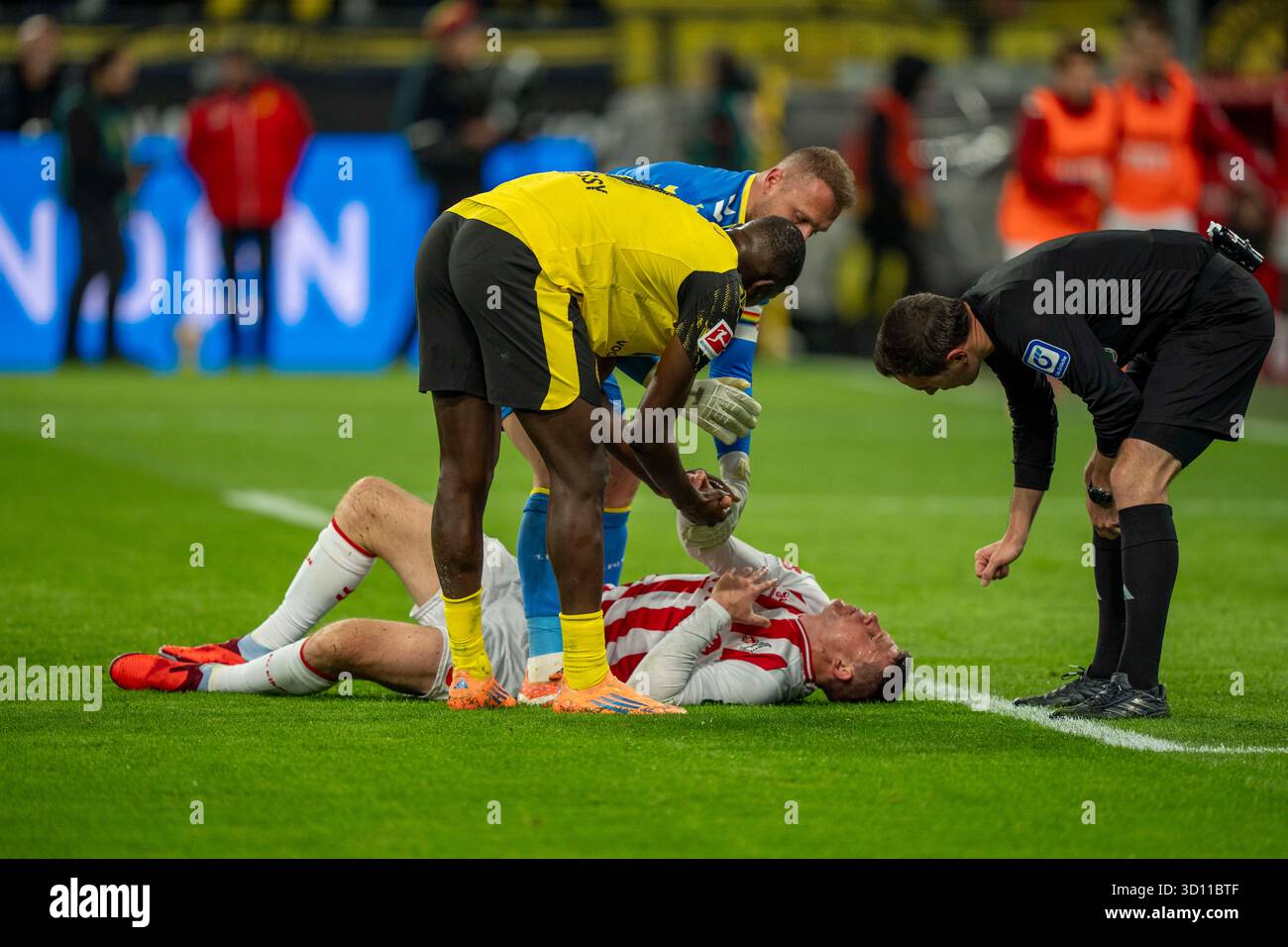 Dominique Heintz (1. FC Köln, #3) liegtr am Boden. Serhou GUIRASSY (Borussia Dortmund, 9). Marvin Schwaebe (1. FC Köln, #1 und Benjamin Brand (DFB Schiedsrichter) kümmert sich um ihn 25.10.2025, Fussball, 1. Bundesliga: Borussia Dortmund – 1. FC Köln in Dortmund, Signal Iduna Park DFL-Vorschriften verbieten die Verwendung von Fotos als Bildsequenzen und/oder Quasi-Video. Stockfoto
