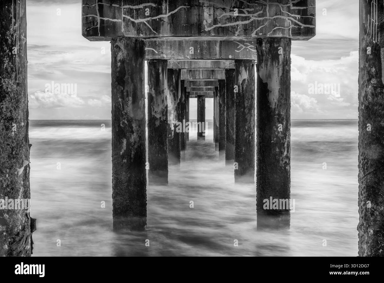Diese lange Exposition, die unter dem Atlantikpier an Floridas Ostküste entstanden ist, verbindet architektonische Symmetrie mit der fließenden Bewegung des Meeres, Trans Stockfoto