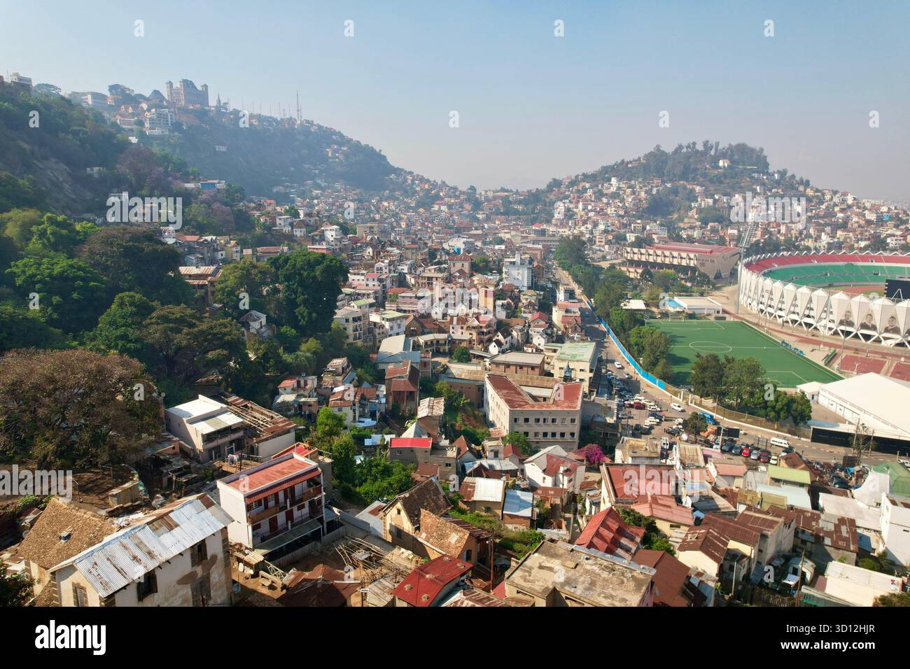 Breites Morgenpanorama von den Hängen der Haute-Ville, das Mahamasina-Stadion, die dichten Häuser von Amparibe und die geschäftigen Stadtadern, die sich zusammenfügen. Stockfoto