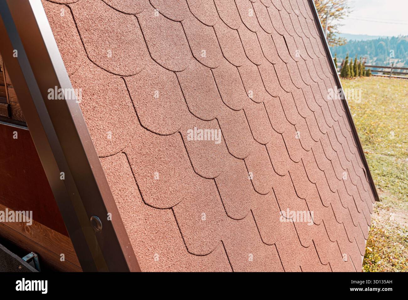 Asphaltschindeln, die ein modernes kleines Hausdach bedecken, zeigen neue Baudetails und architektonische Muster Stockfoto
