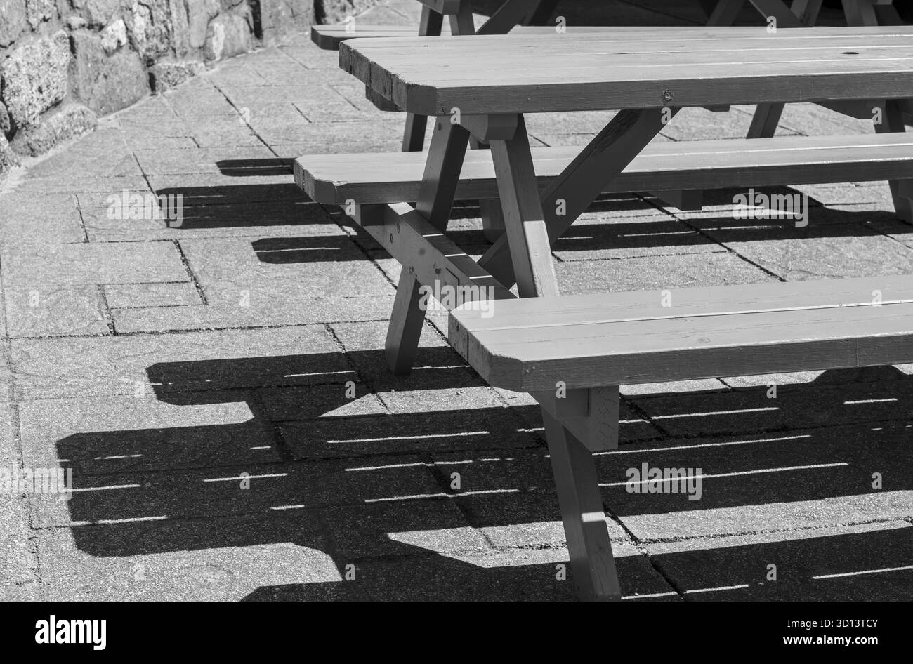 Picknickbank in der Sonne mit dem Schatten auf dem Boden, Verenigd Koninkrijk Stockfoto
