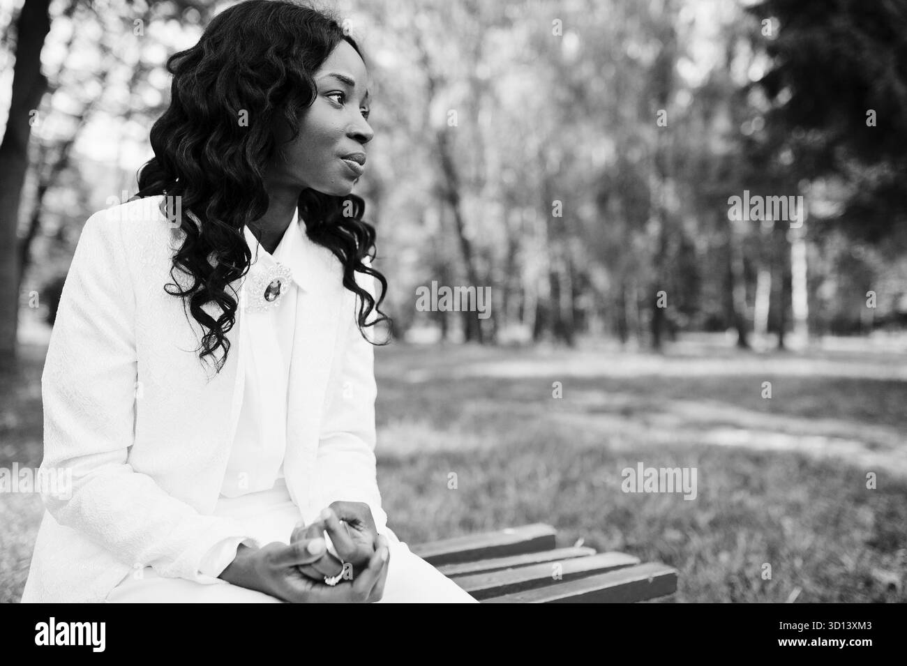 Porträt der hübsche schwarze afroamerikanische Mädchen sitzen auf der Bank am grünen park Stockfoto