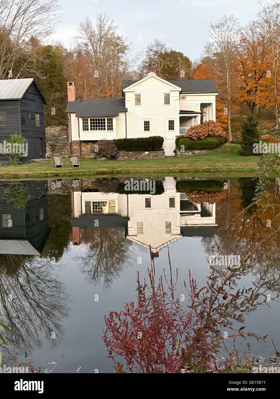 Malerisches weißes Haus spiegelt sich in einem Teich - Smartphone-aufgenommenes Stockfoto