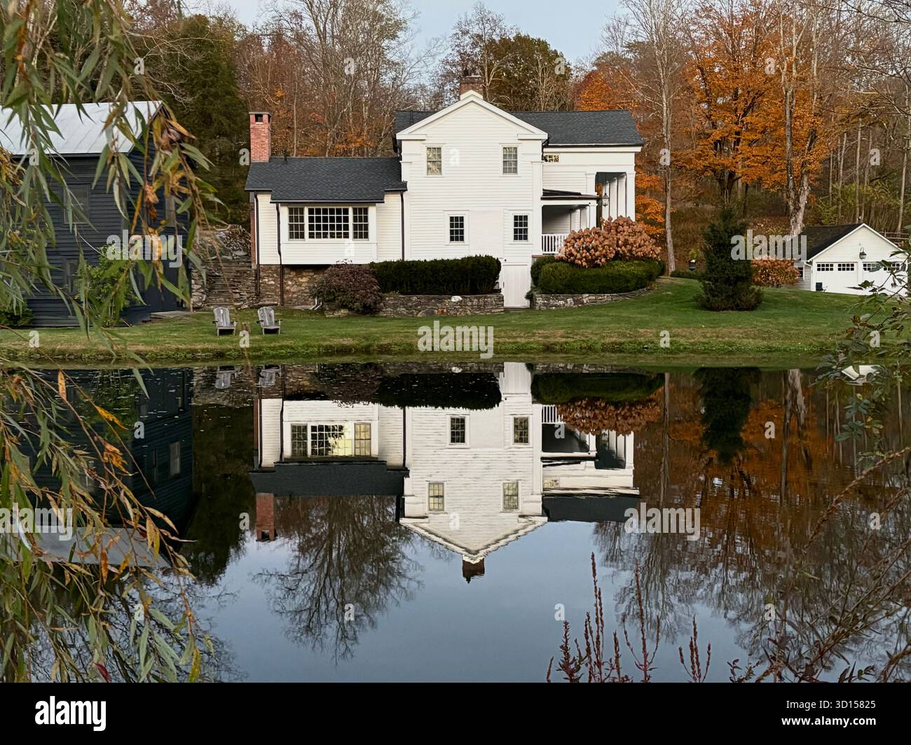 Ein malerisches weißes Haus, das sich in einem Teich spiegelt. - Smartphone-aufgenommenes Stockfoto