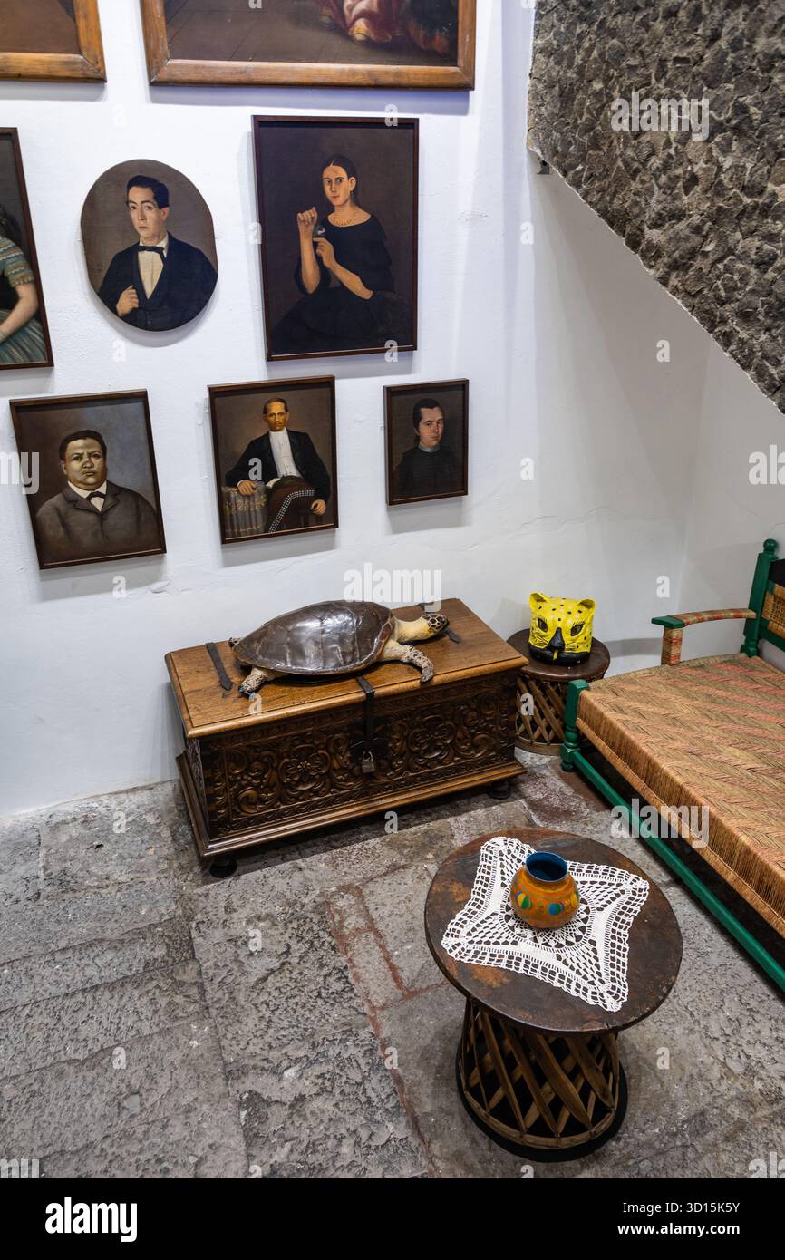 Porträts und geschnitzte Möbel im Haus von Frida Kahlo, La Casa Azul, Coyoacán, Mexiko-Stadt. Stockfoto