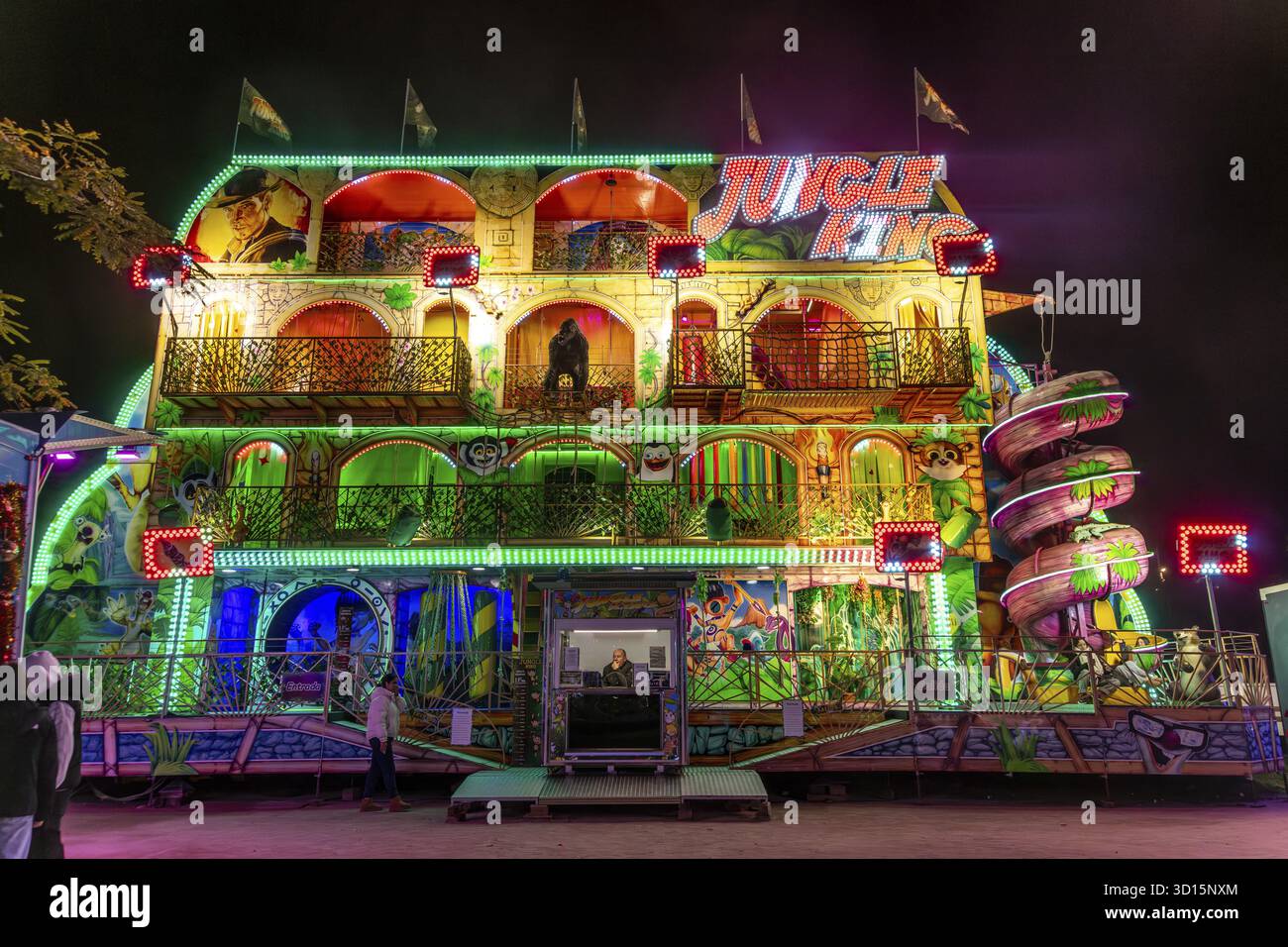Barcelona, Katalonien - Spanien - 01-07-2025: Ein lebendiges, im Dschungel-Stil gehaltenes Funhouse mit Neonlichtern, bemalter Tierdekoration und einer spiralförmigen Rutsche bei Nacht Stockfoto