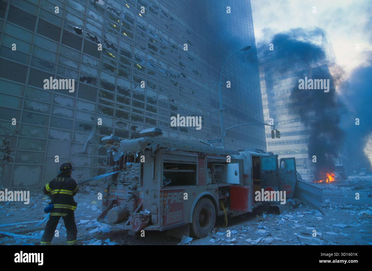 New-york-City-Feuerwehrmann-ziehen-Wasserschlauch-vom-Feuerwehrwagen-zwischen-Trümmern-und-Feuer am 11/2001. September Stockfoto