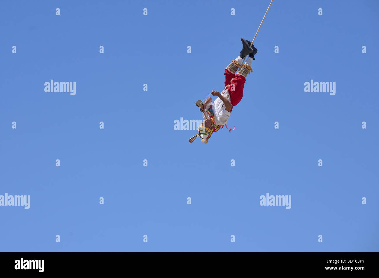 Crisanto Méndez Jiménez spielt Flöte und Trommel, während er und drei andere Voladores in Chapala, Mexiko, auf die Erde herabsteigen. Stockfoto