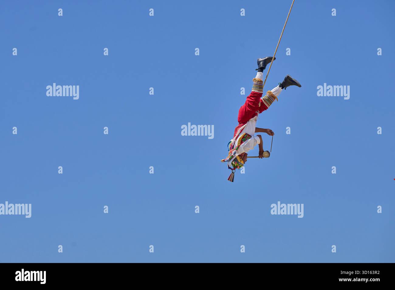 Crisanto Méndez Jiménez spielt Flöte und Trommel, während er und drei andere Voladores in Chapala, Mexiko, auf die Erde herabsteigen. Stockfoto
