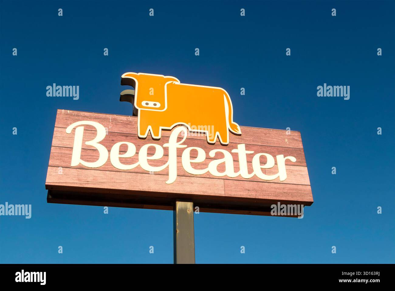 Beefeater Restaurant Schild mit einem stilisierten orangen Kuhlogo auf einem Holzbrett vor klarem Himmel in whitley Bay tyne & Wear Stockfoto