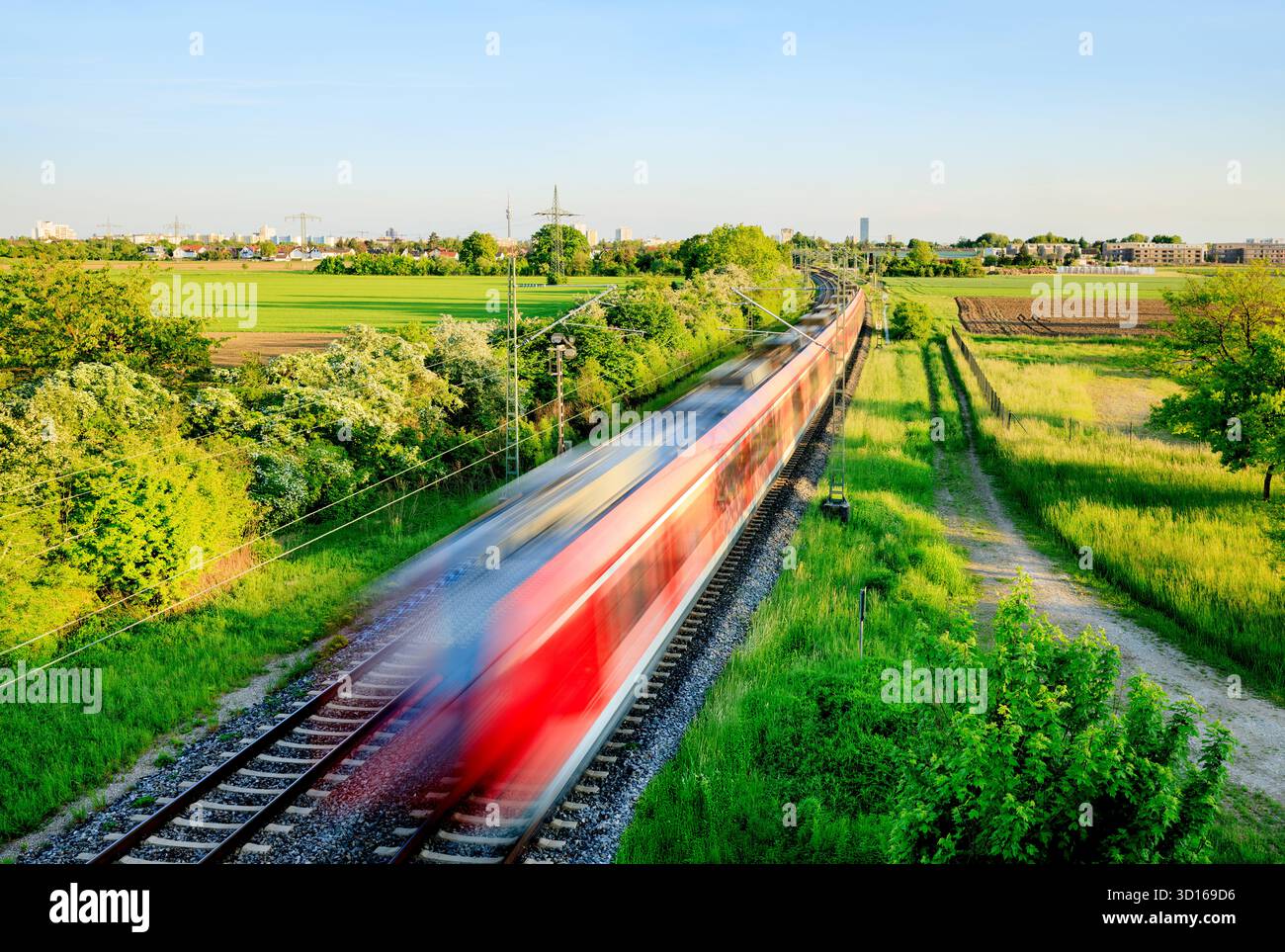 Schnellzug in grüner Landschaft - regionale Verbindung zwischen Stadt und Land - Symbol und Konzept des öffentlichen Nahverkehrs, Pendler, Rush Hour und in Stockfoto
