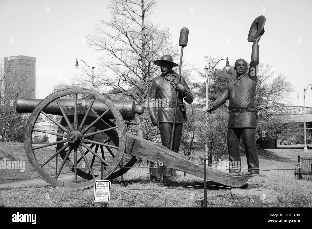 Schwarzweißfoto von Bronzestuben und Kanonen am Centennial Land Run Monument in Bricktown Stockfoto