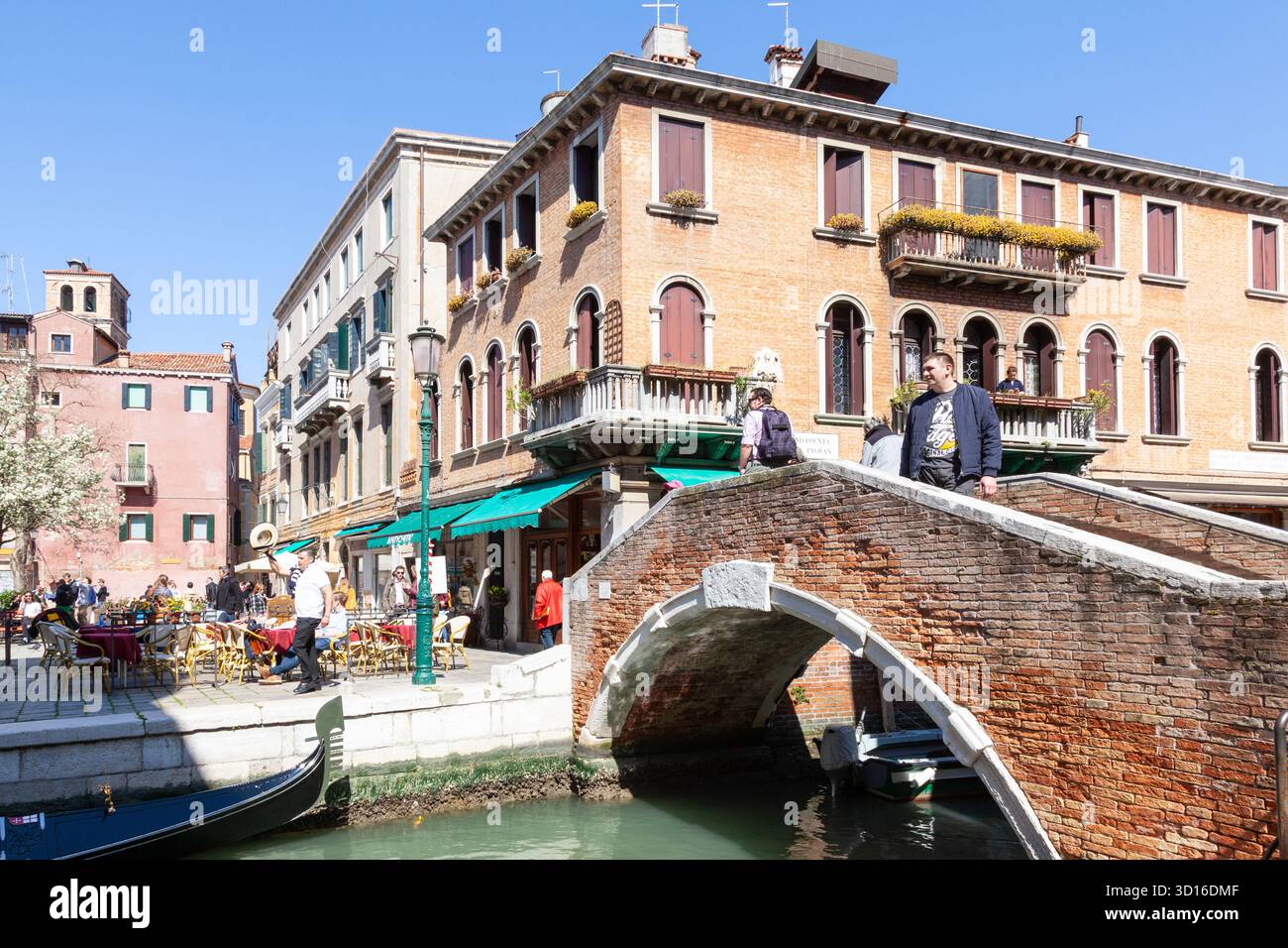 Gondolier, der im Frühling im Open-Air-Restaurant, Campo Santa Maria Nova, Cannaregio, Venedig, Venetien, Italien, verwöhnt Stockfoto