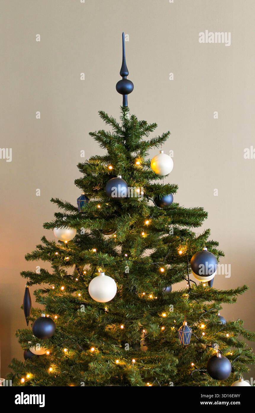 Weihnachtsbaum mit Lichtern und Dekorationen in Blau und weiß Stockfoto