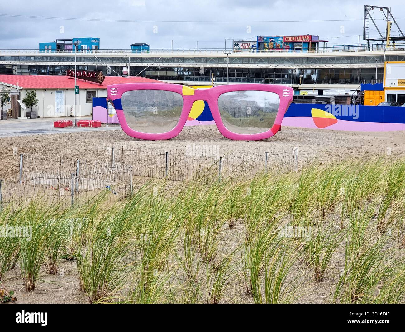Riesige pinkfarbene Sonnenbrille: Kunstwerk „Scheveningen is Look out for you“ am Strand von Scheveningen, den Haag, Niederlande - Smartphone-aufgenommenes Stockfoto
