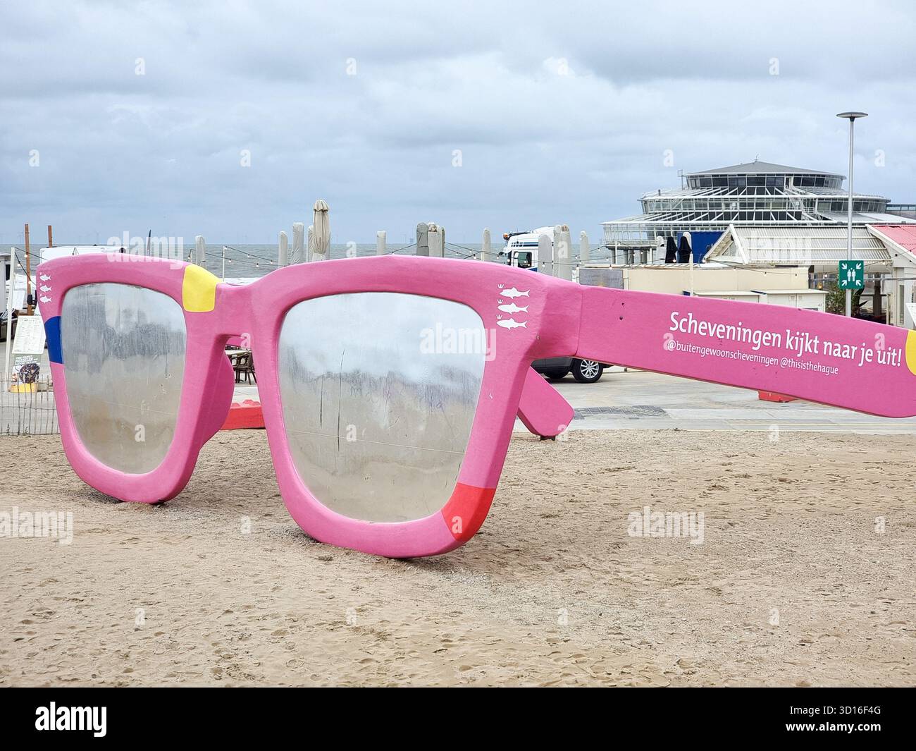 Riesige pinkfarbene Sonnenbrille: Kunstwerk „Scheveningen is Look out for you“ am Strand von Scheveningen, den Haag, Niederlande - Smartphone-aufgenommenes Stockfoto