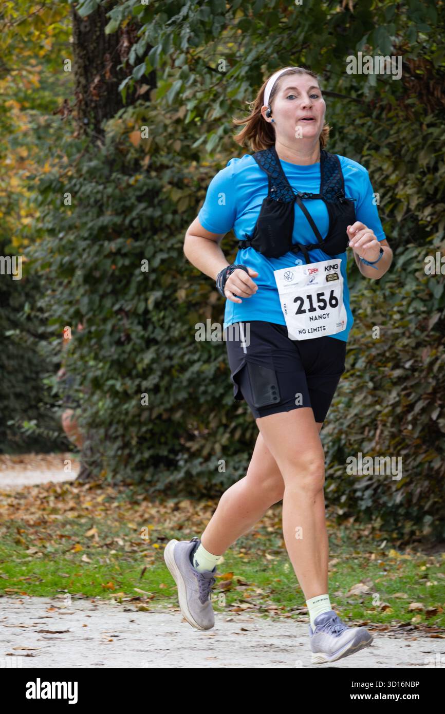 Frau mittleren Alters, die durch den friedlichen Park läuft, in sportlichem Outfit, das sich auf Fitness Gesundheit und Gleichgewicht im aktiven Outdoor-Lifestyle konzentriert. Stockfoto