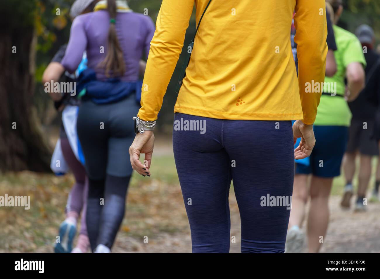 Frau mittleren Alters, die durch den friedlichen Park läuft, in sportlichem Outfit, das sich auf Fitness Gesundheit und Gleichgewicht im aktiven Outdoor-Lifestyle konzentriert. Stockfoto