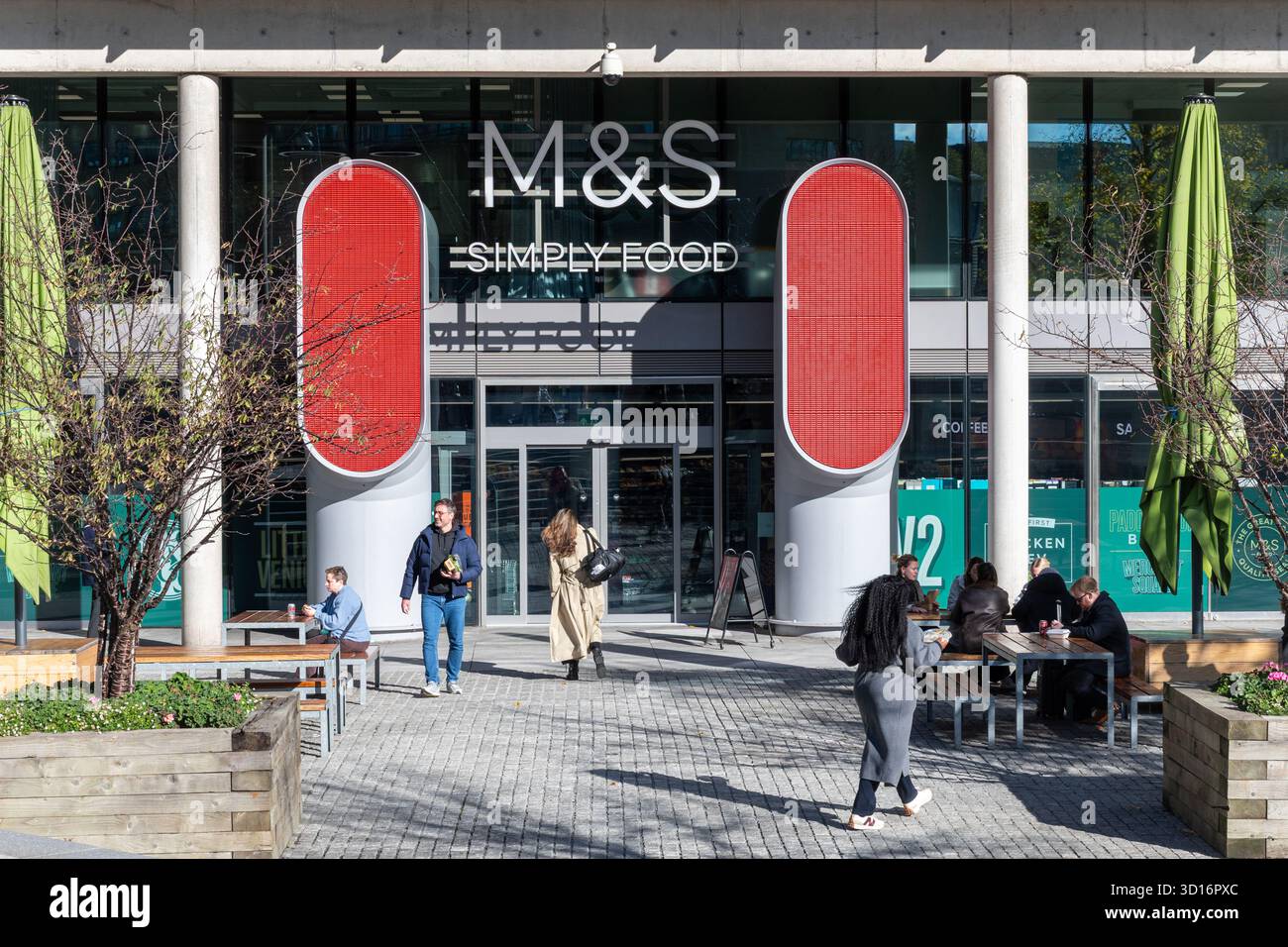 M & S Simply Food Shop mit Leuten, die draußen essen, in der North Wharf Road im Paddington Basin in London, England, Großbritannien Stockfoto
