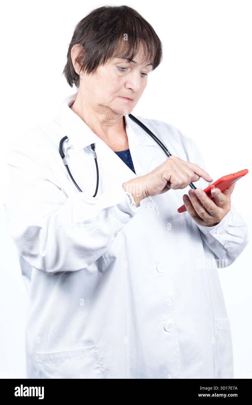 Leitende Ärztin mit weißem Labormantel und Stethoskop, mit einem roten Smartphone, repräsentiert digitale Gesundheitsversorgung, Online-Konsultationen, Stockfoto