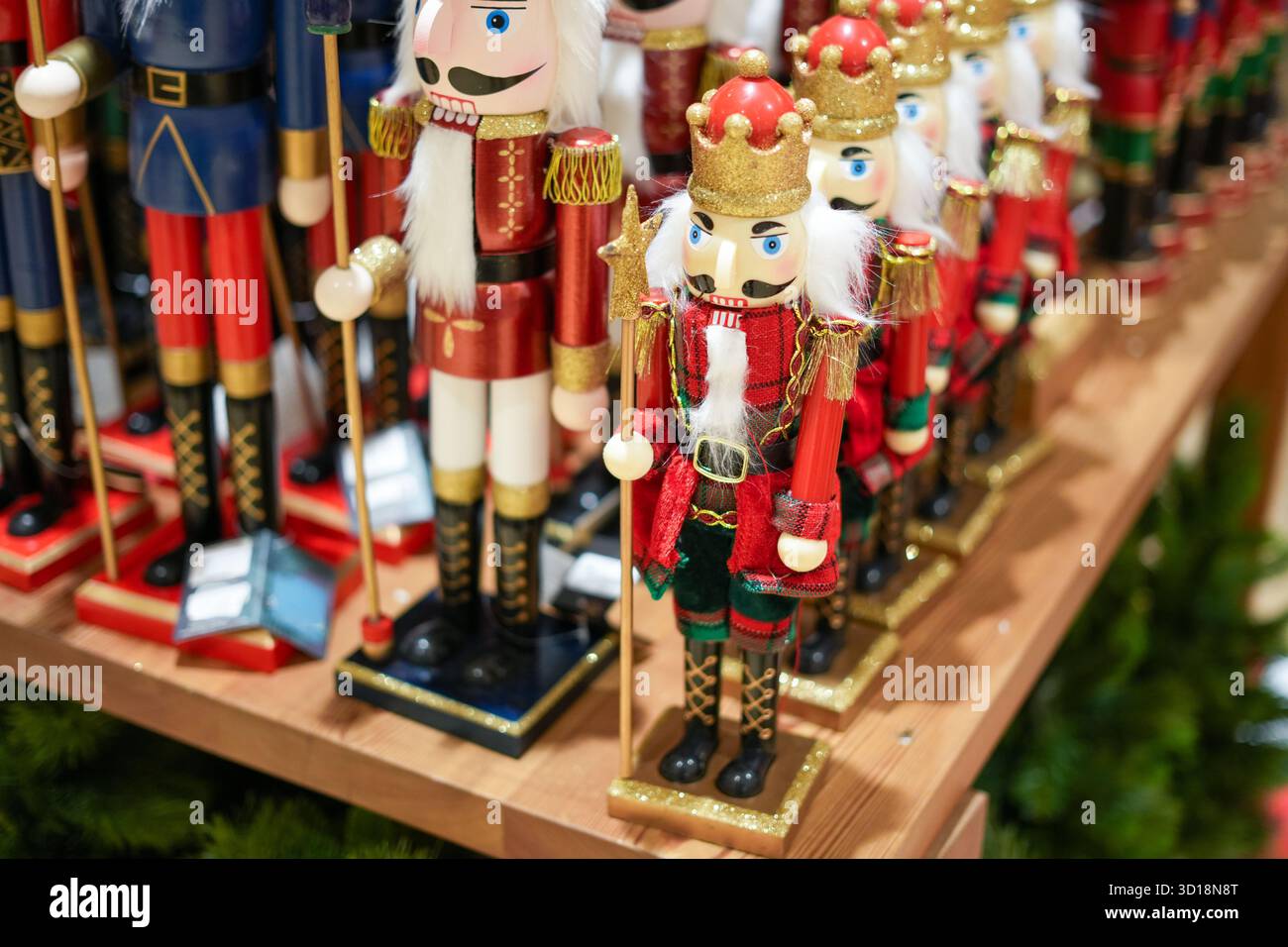 Klassische Nussknacker-Soldaten in Rot, Grün und Gold auf einem Regal – ideal für nostalgische Weihnachtsdekoration und traditionelle Weihnachtskampagnen. Stockfoto