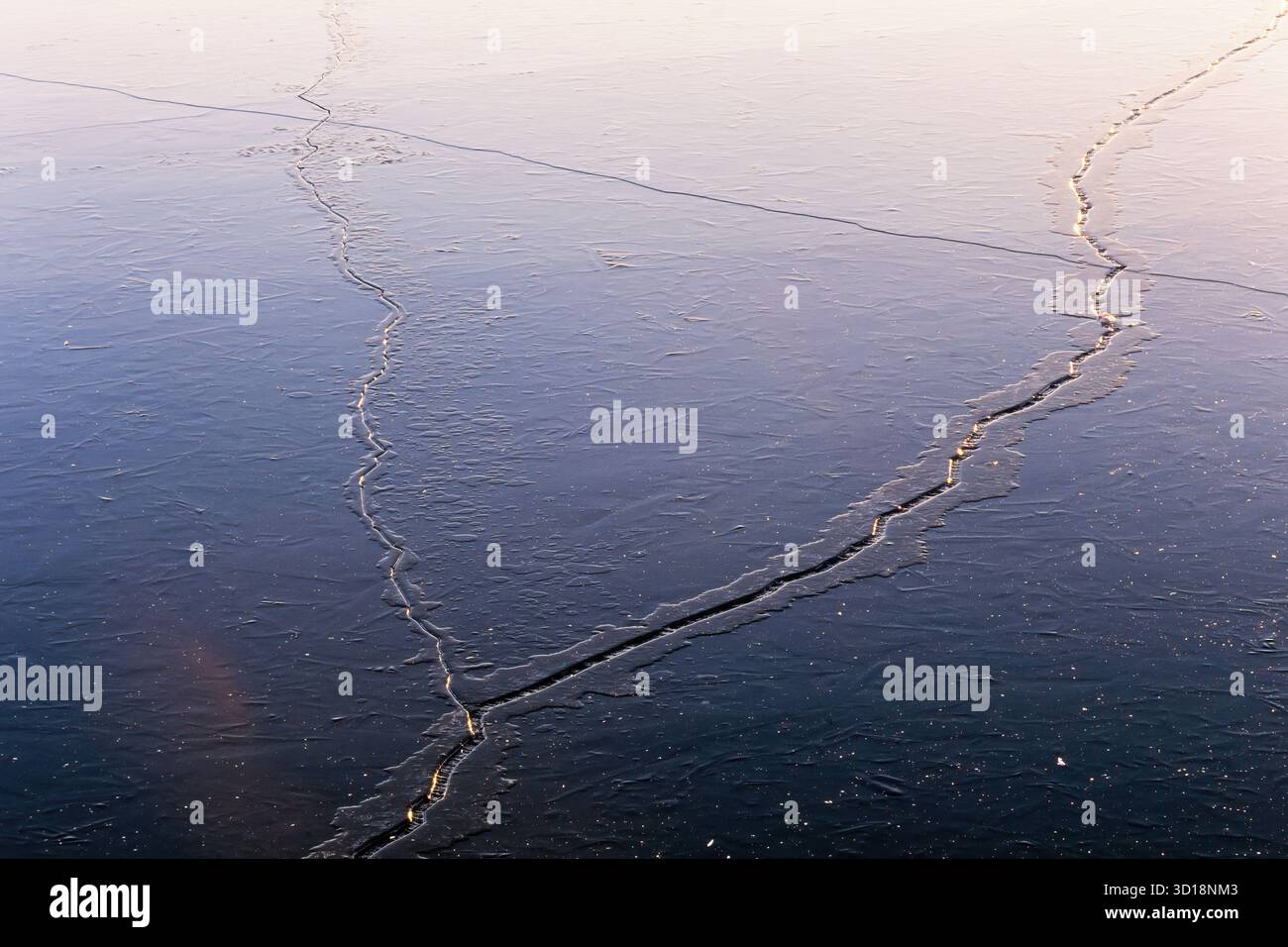 Risse im Eis auf einem See an einem kalten Wintertag Stockfoto