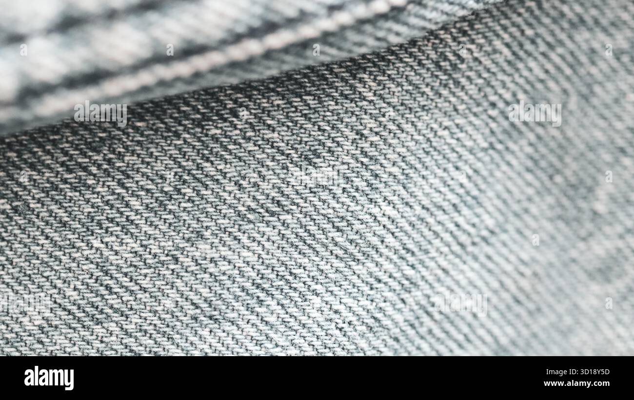 Makroaufnahme aus hellgrauem Denim-Material mit komplizierter Textur und Webmuster Stockfoto