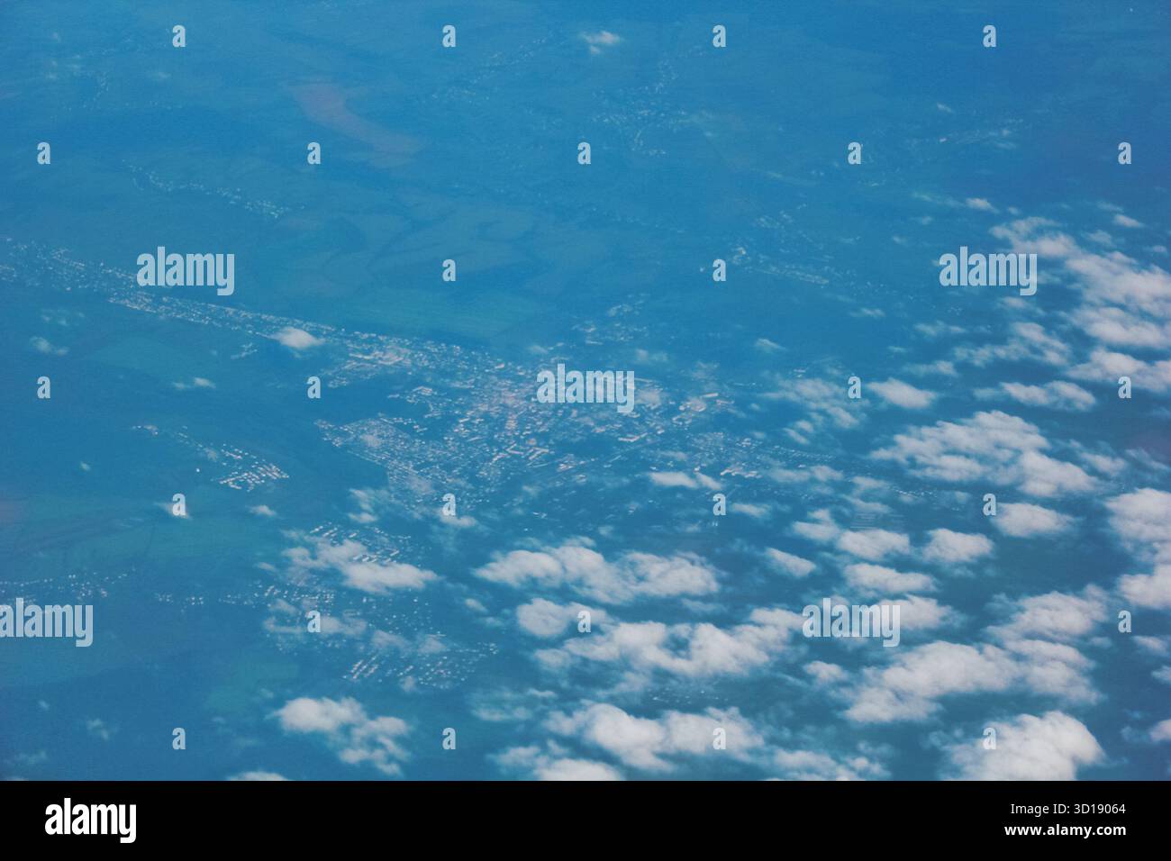 Dies ist ein Luftbild, das eine Landschaft aus großer Höhe zeigt, wahrscheinlich aus einem Flugzeug. Darunter befindet sich ein großer Wasserkörper mit Stockfoto