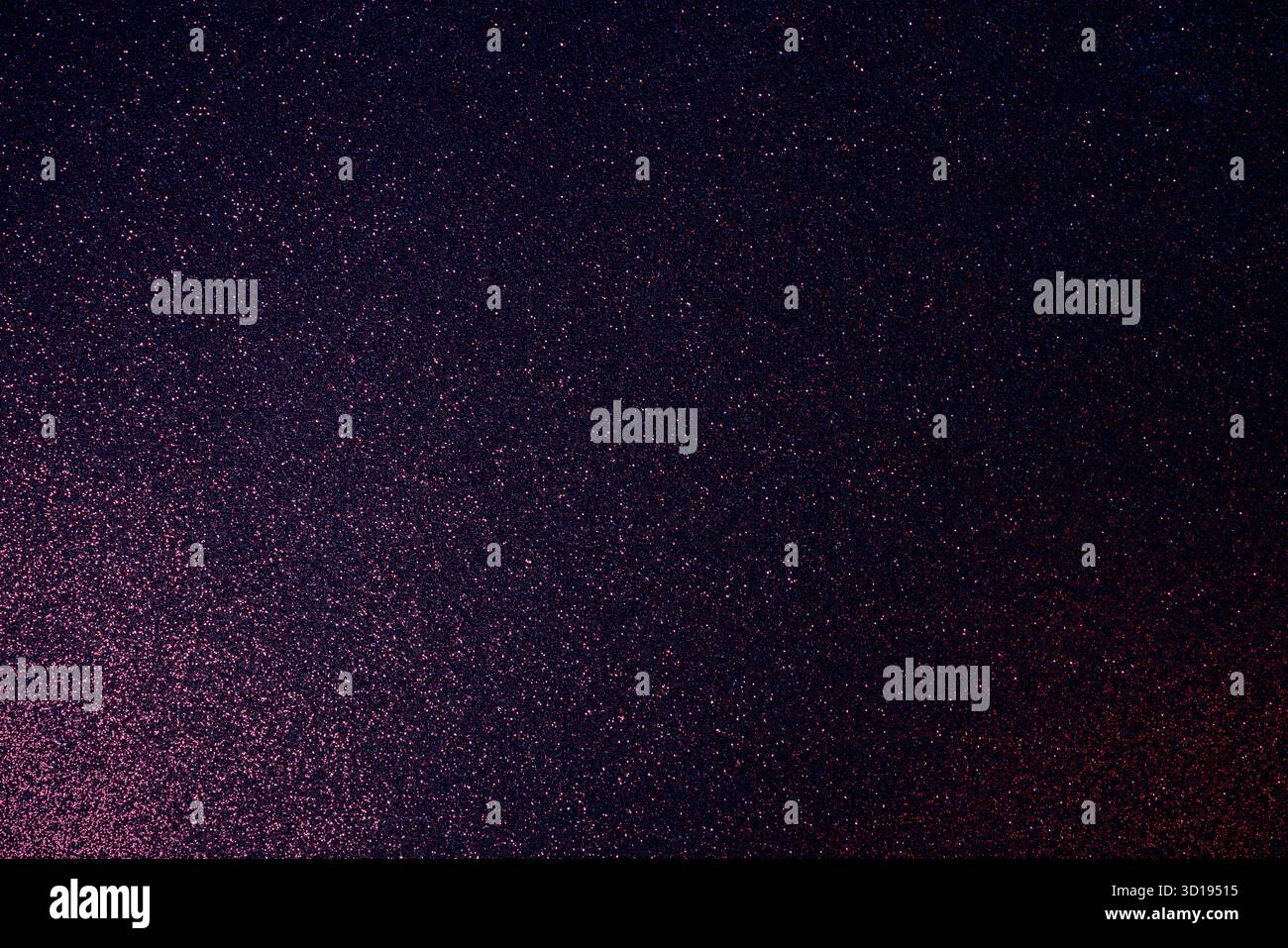 Granulierte, dunkel-violette Glitzeroberfläche, die mit burgunderrotem Schimmer leuchtet, und diagonales Licht offenbart verstreute Funkeln auf einem stimmungsvollen abstrakten Hintergrund Stockfoto