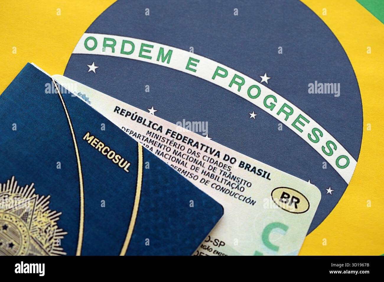 Brasilianischer Führerschein für ein Kraftfahrzeug mit Reisepass auf brasilianischer Flagge in Nahaufnahme Stockfoto