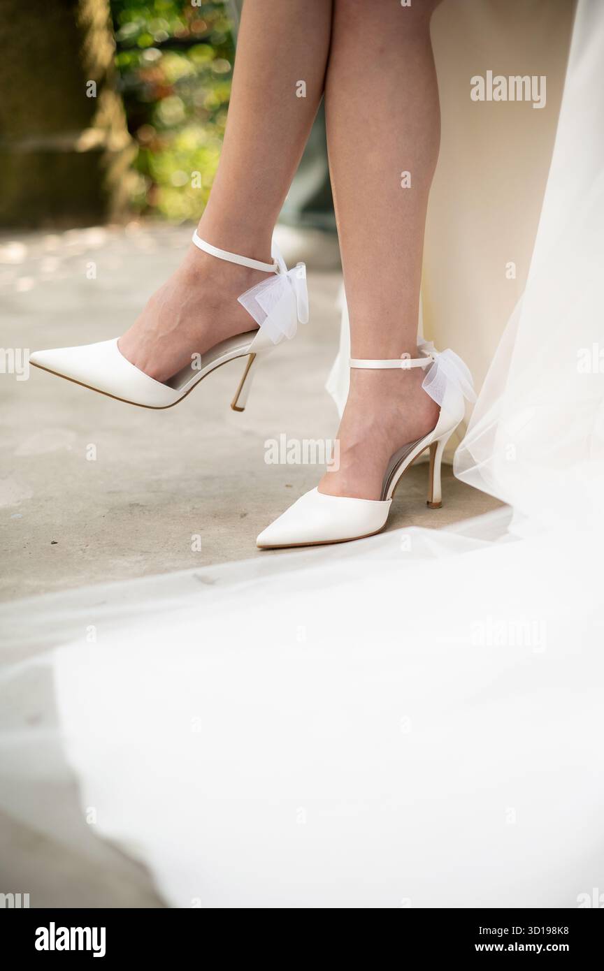 Die eleganten weißen High Heels der Braut mit Schleife Stockfoto