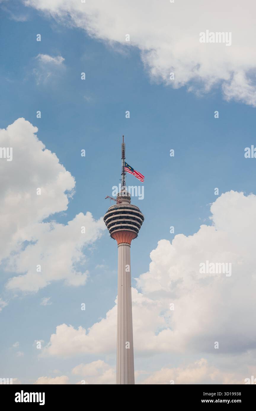 KL Tower mit malaysischer Flagge gegen den blauen Himmel, Kuala Lumpur, Malaysia Stockfoto