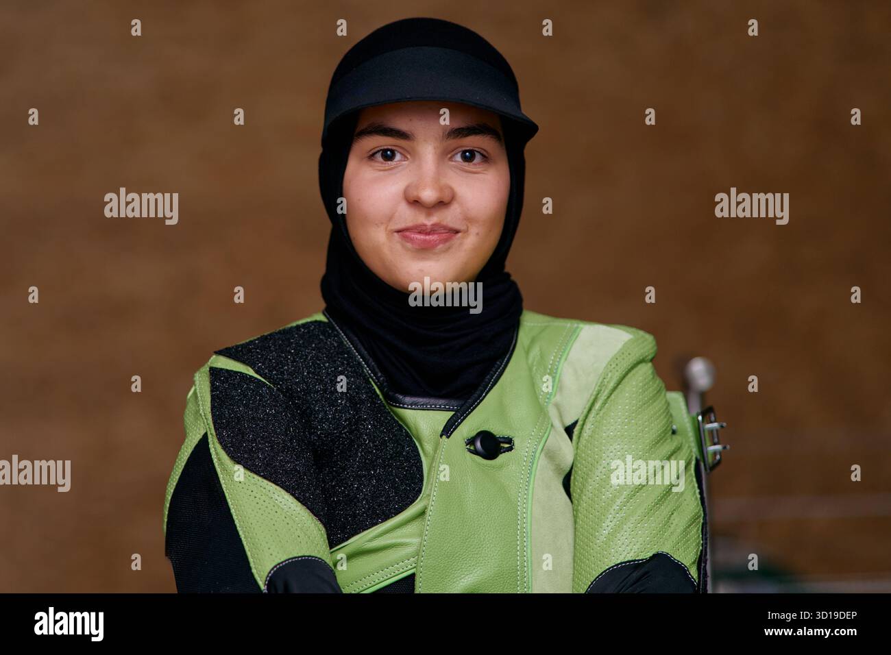 Porträt einer jungen muslimischen Frau mit Hijab und Schießausrüstung, Blick auf die Kamera, Aufnahme im Studio, selbstbewusste Athletin, Entschlossenheit Stockfoto